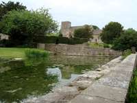 Chedworth Church looking across garden pond of nearby house